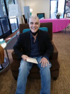 A man in a chair smiling.