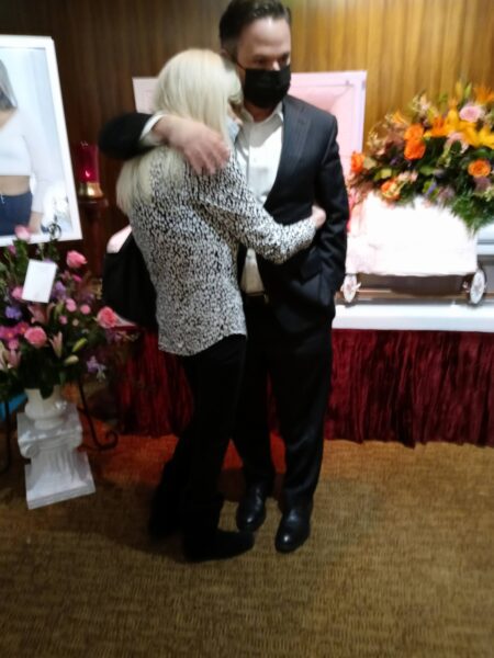 Man comforting a woman at the funeral.