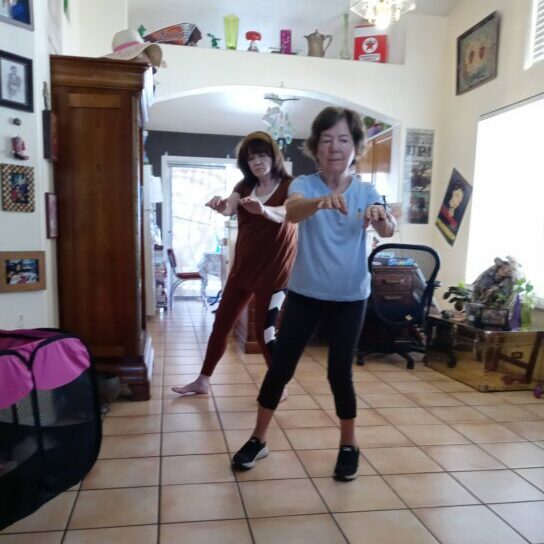 Doris Fong instructs Kristine in Tai Chi.